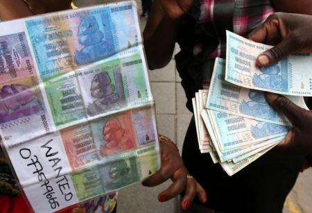 An illegal foreign currency trader counts notes at a local bus station in the capital Harare, Zimbabwe