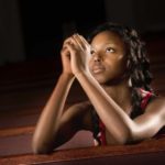 God hears prayers: A woman kneeling and praying to God