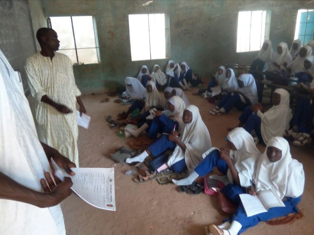 Students sit on bare floor as administrator locks away furniture