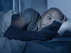 internet addict man awake at night in bed with mobile phone 696x522