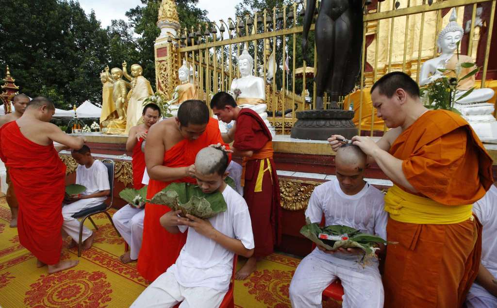 Soccer coach Ekkapol Chantawong right and members of the team who were rescued last week from a flooded cave have their heads shaved in a traditional Buddhist ceremony