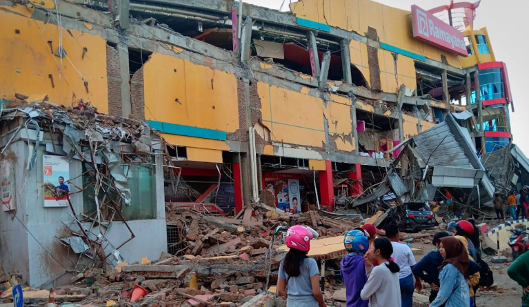 Residents stand in front of a damaged shopping mall after an earthquake hit Palu, Sulawesi Island, Indonesia September 29, 2018. Antara Foto/Rolex Malaha via REUTERS