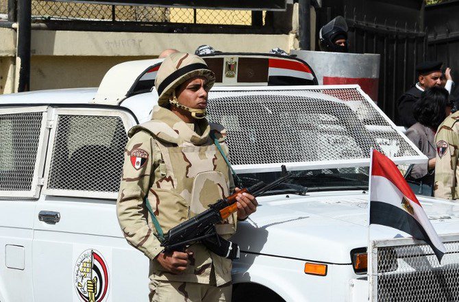 A picture taken on March 26, 2018 shows an Egyptian army conscript standing guard outside a polling station in the capital Cairo on the first day of the 2018 presidential elections. - Egyptians head to the polls in a three-day vote to choose between incumbent Abdel Fattah al-Sisi and little-known candidate Moussa Mostafa Moussa, who has struggled to make the case he is not Sisi's minion. (Photo by FETHI BELAID / AFP)