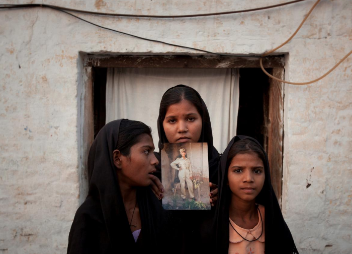  FILE PHOTO: The daughters of Pakistani Christian woman Asia Bibi pose with an image of their mother while standing outside their residence in Sheikhupura located in Pakistan's Punjab Province November 13, 2010. Standing left to right is Esha, 12, Sidra, 18 and Eshum, 10. REUTERS/Adrees Latif/File Photo