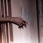 prisoners arms resting on cell bars picture id119078180