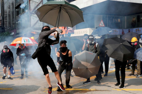 An anti-government demonstrator throws back a tear gas canister during a protest march in Hong Kong, China, October 20, 2019. REUTERS/Kim Kyung-Hoon