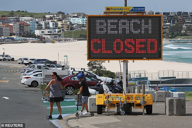 People walk past a 'beach closed' sign at Sydney's Bondi on Wednesday afternoon (pictured)