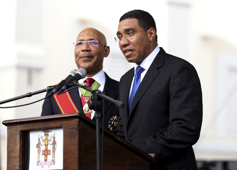 Jamaica's Prime Minister Andrew Holness (R) addresses the audience next to Jamaica's Governor-General Sir Patrick Allen during his swearing-in ceremony in Kingston,