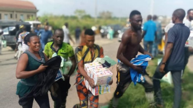Nigerians carrying food items collected from Covid-19 Palliatives Warehouse