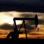 FILE PHOTO The sun sets behind a crude oil pump jack on a drill pad in the Permian Basin in Loving County