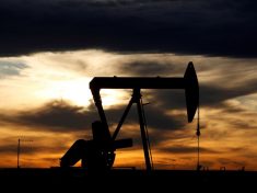 FILE PHOTO: The sun sets behind a crude oil pump jack on a drill pad in the Permian Basin in Loving County