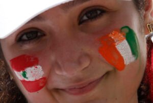 A member of Lebanese community in Ivory Coast smiles with her face painted with Ivory Coast and Lebanon flags colours at the Felix Houphouet Boigny international airport in Abidjan on March 14