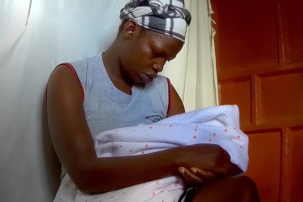 Adama cradling her baby, moments before she was supposed to sell him
