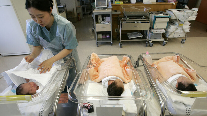 A nurse attending to new borns in a baby ward in South Korea