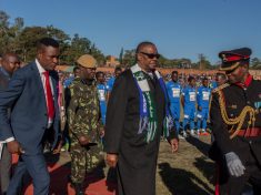 Malawi President Arthur Peter Mutharika (C) wears two football club scarves of the teams of a friendly match as part of national celebrations to commemorate the country's 54th Independence Anniversary, July 6, 2018. (Photo by Amos Gumulira / AFP)