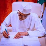 President Buhari Signing a document -