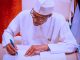 President Buhari Signing a document -