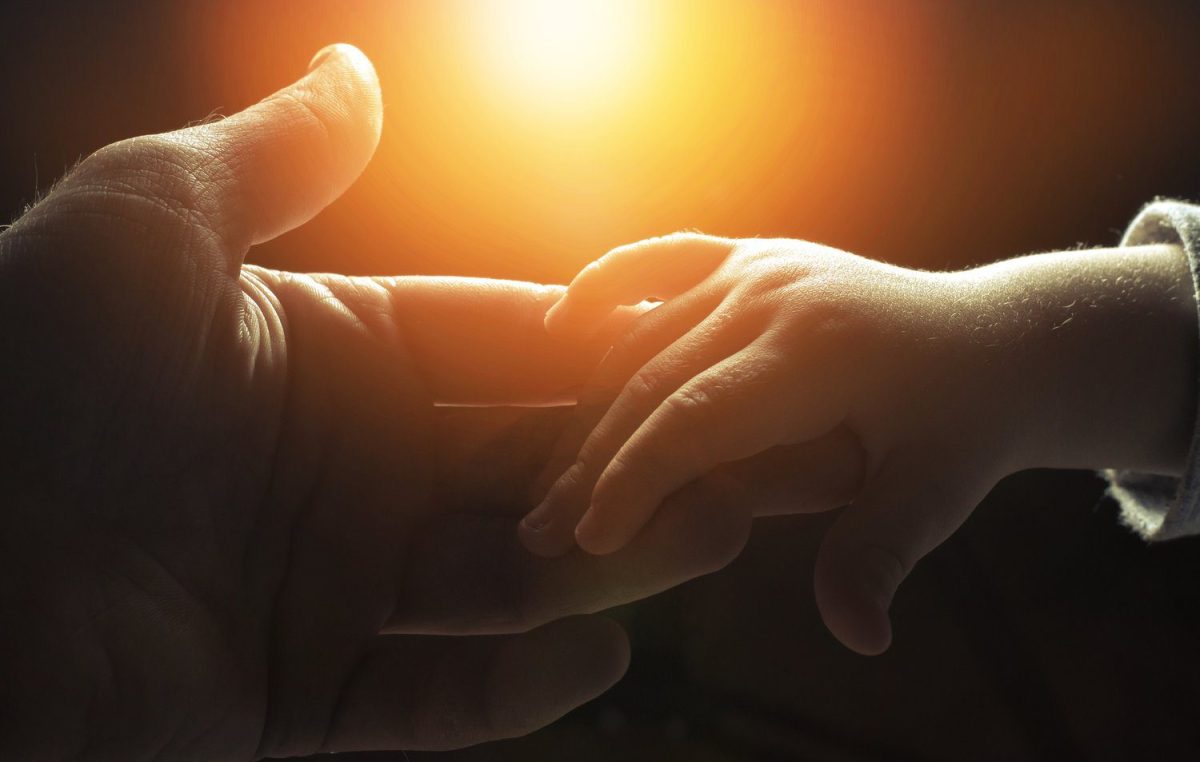 Hand of a man and a child's hand holding unto him