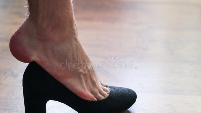 Man trying to wear ladies shoes